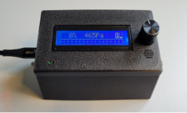 Op de voorkant: draaiknop, LCD-scherm, Luidspreker
